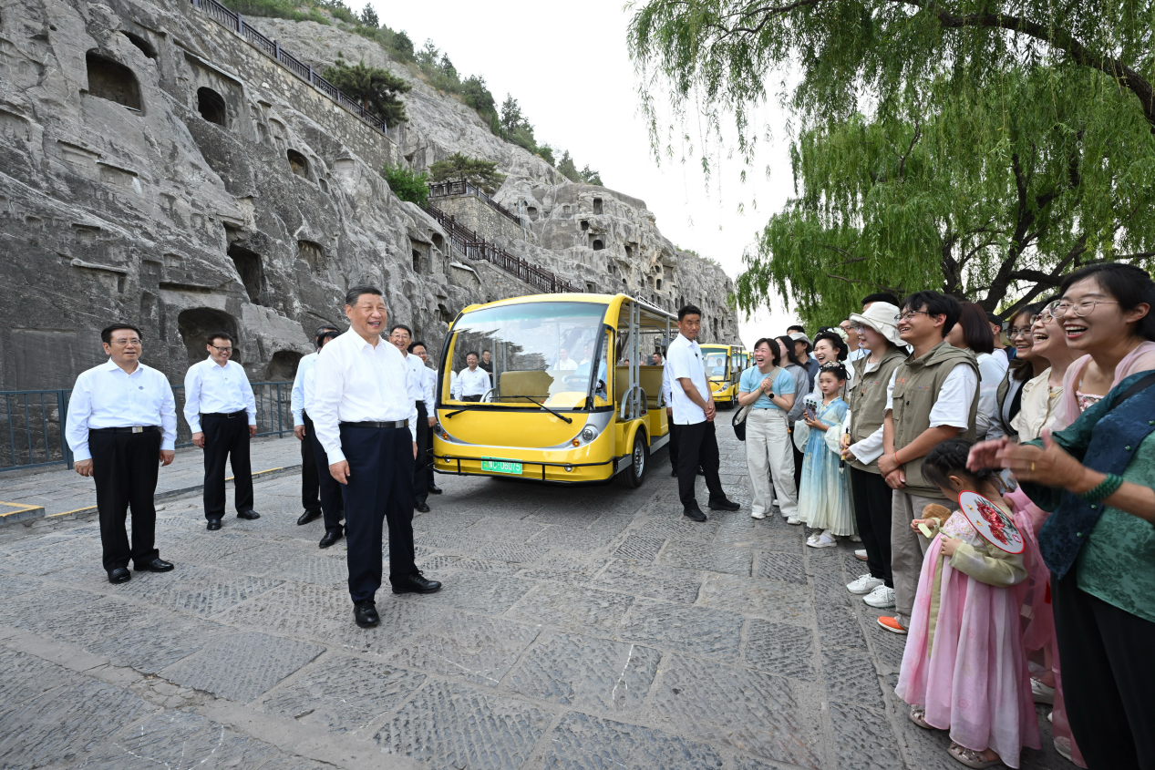 5月19日，習(xí)近平在洛陽龍門石窟考察時，同游客親切交流。